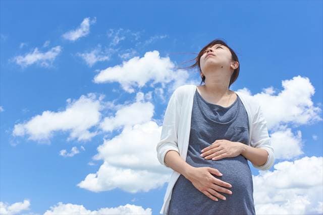 空を見上げる妊婦