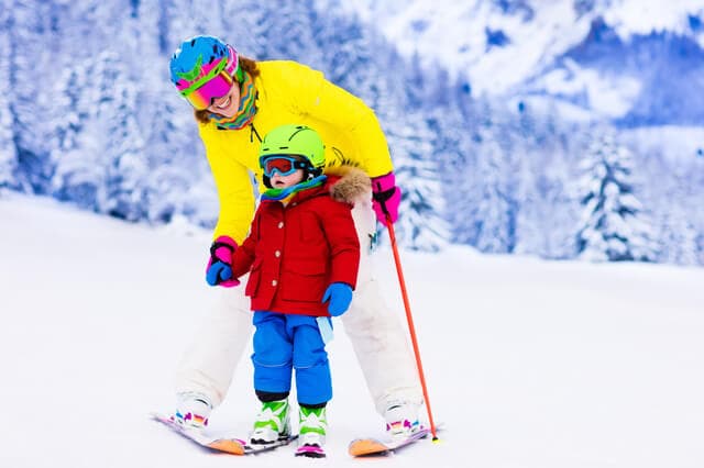 スキーを教えるお母さん