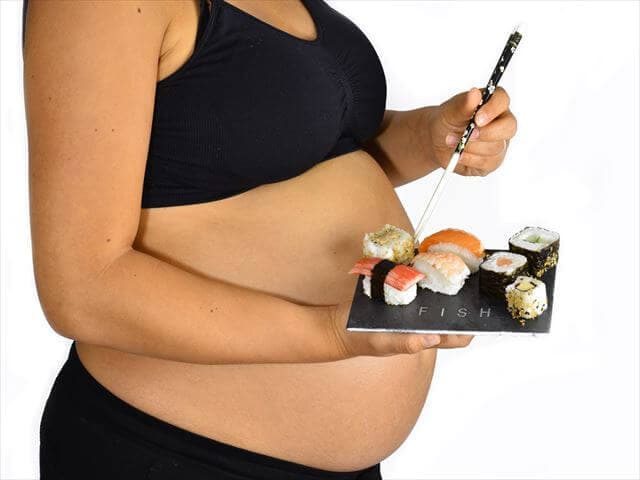 お寿司を食べる妊婦