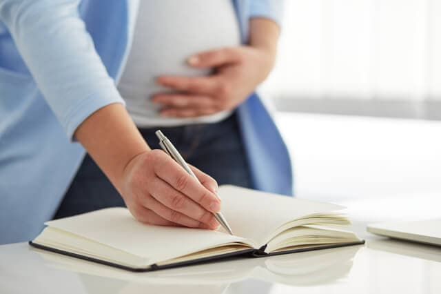 日記を書く妊婦