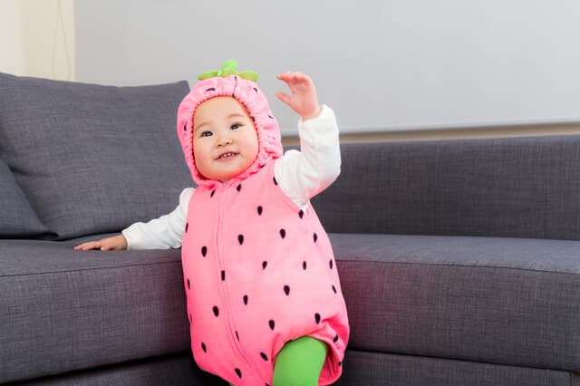 イチゴの衣装を着る赤ちゃん