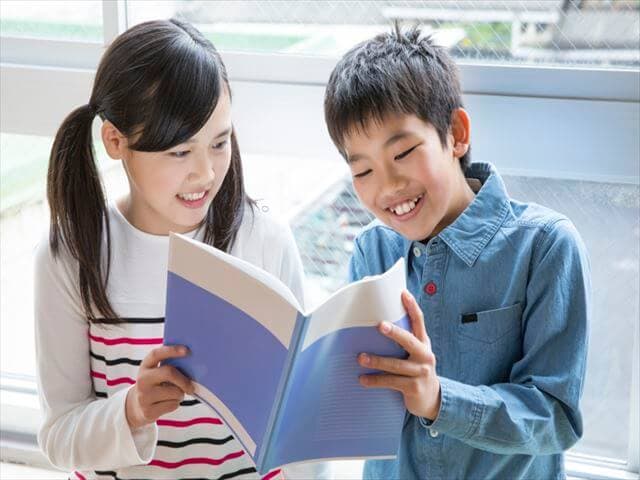 一緒に本を読む小学生