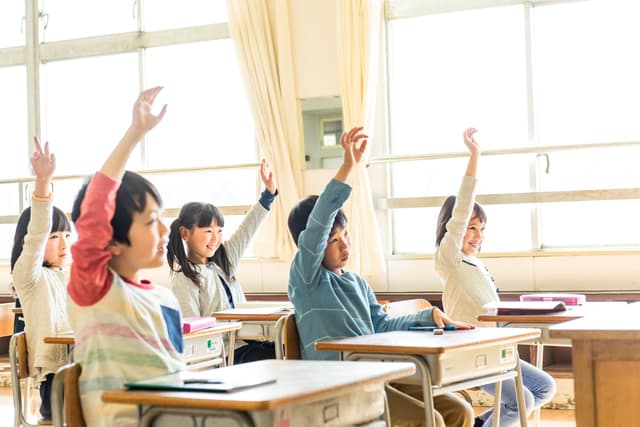 教室で挙手する子どもたち